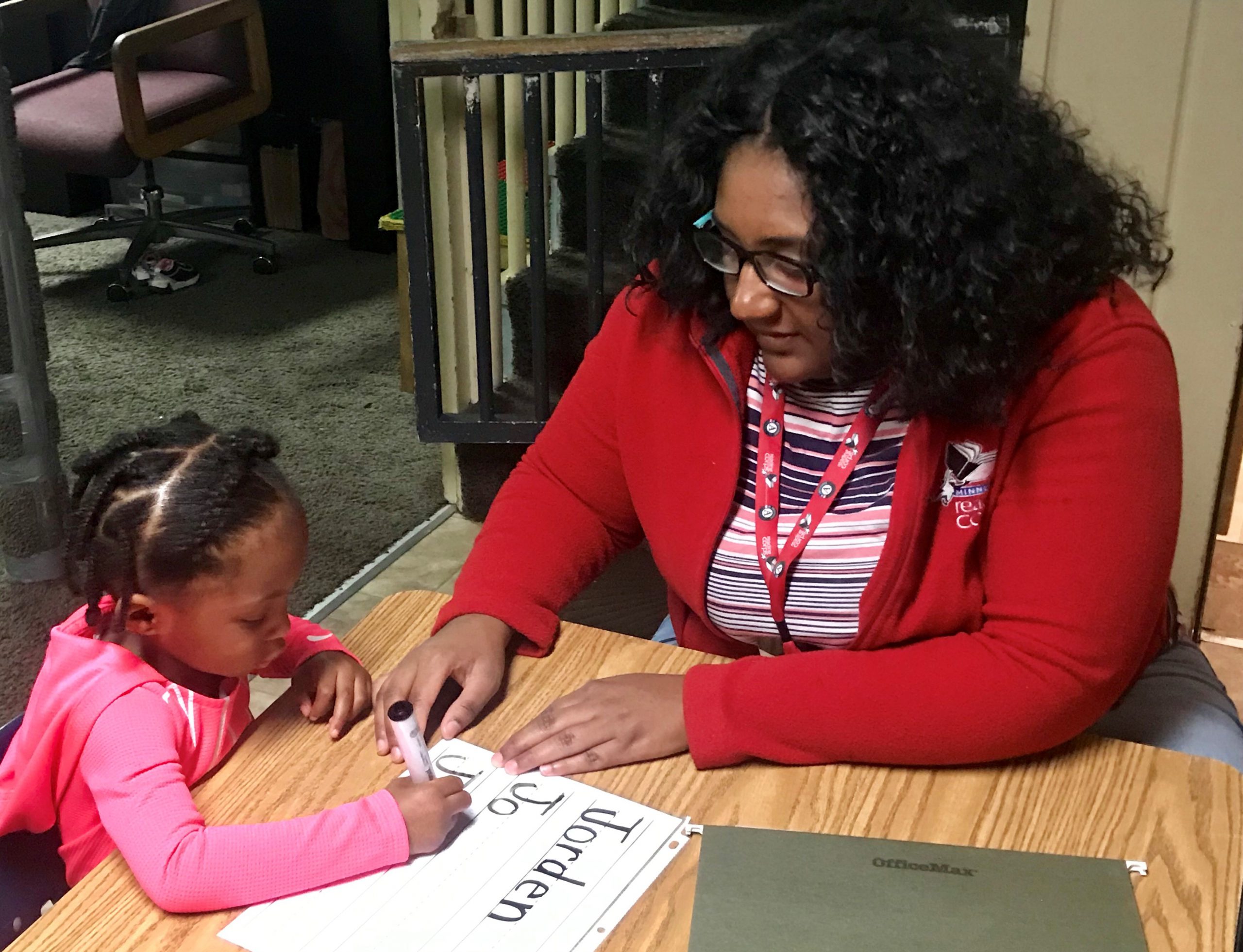 Reading Corps tutor Aurora teaching young girl how to write her name